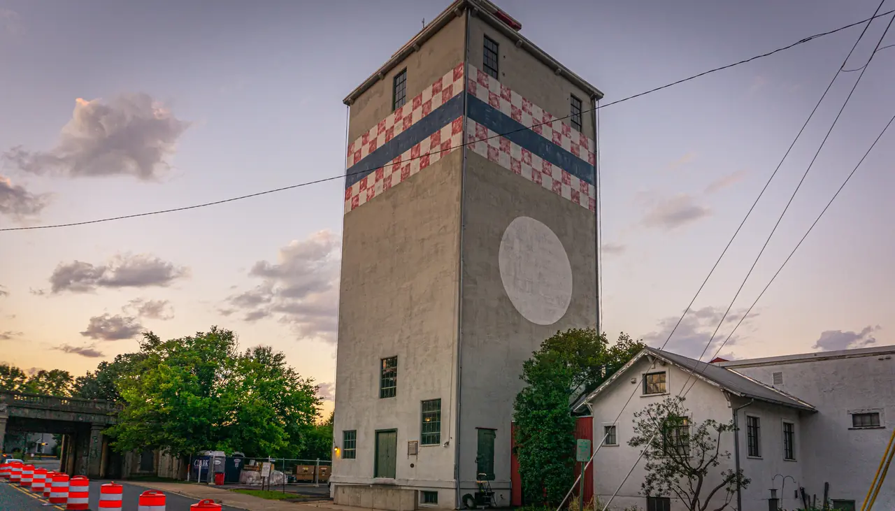 The Fredericksburg tower at sunset, with trees and shrubs beside the adjoining building.